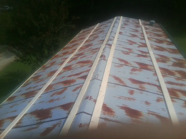 Rusted metal roof panels with new wood purlins before replacement — Storm Damage Roof Repair in Randalia by Roofing Brothers