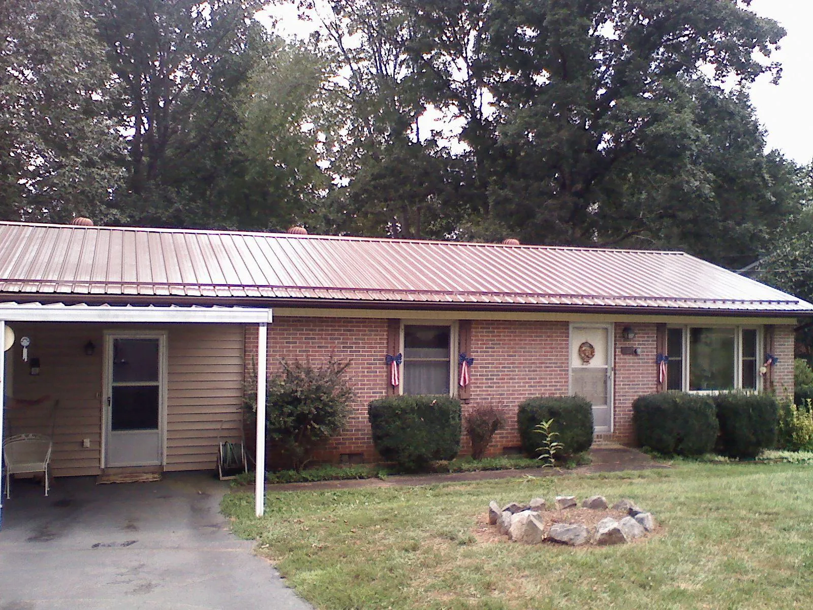 Bronze metal roof and carport on a brick ranch home — Roof Repair work by our crew in Randalia