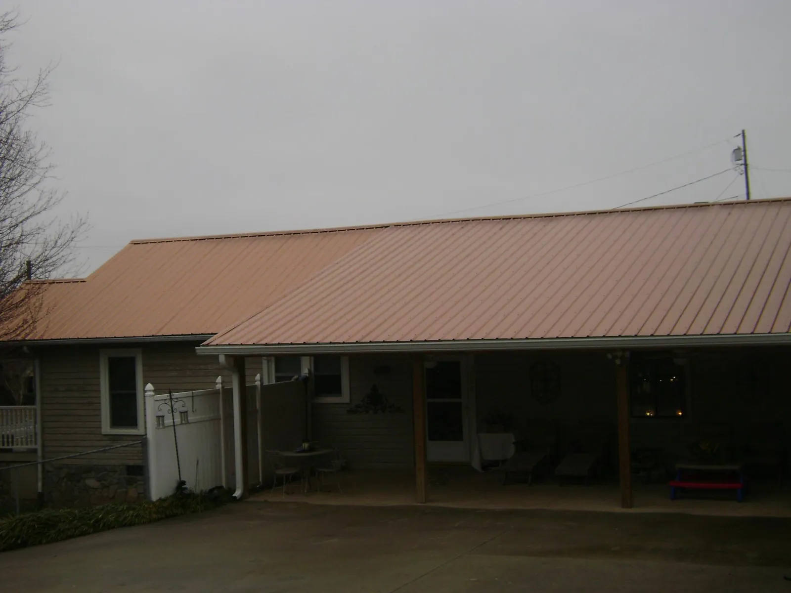 Copper toned metal roof over a wide covered patio in Randalia